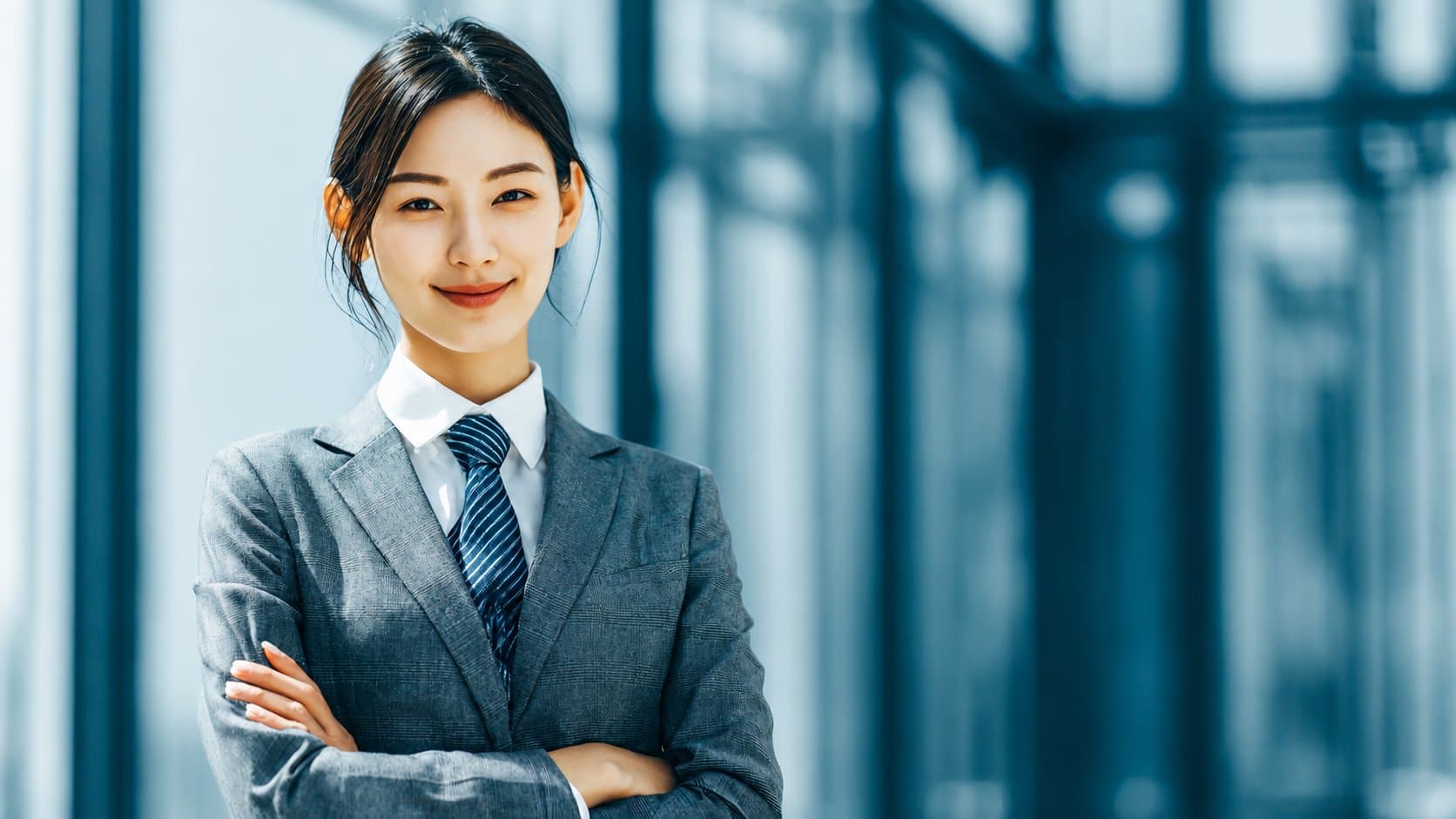 專業的客服人員身著套裝，自信地站在現代化辦公大樓內